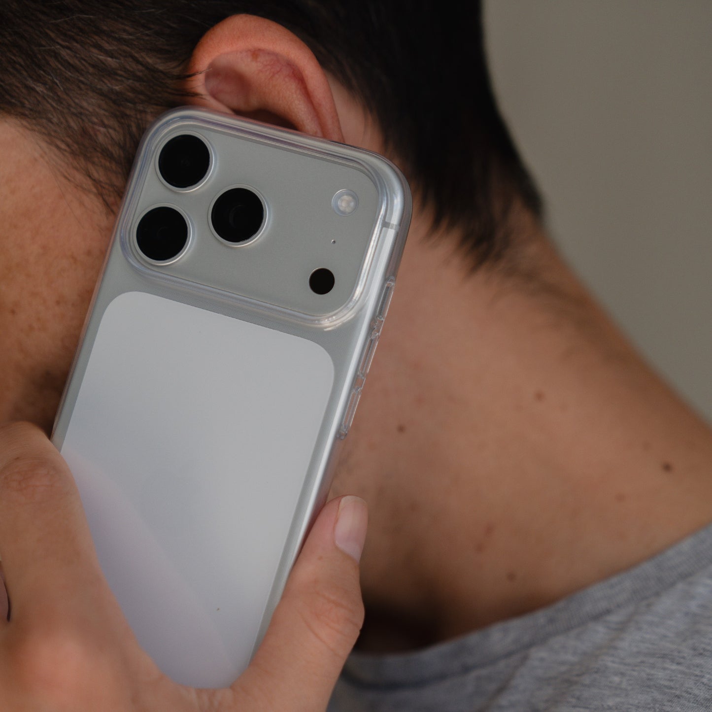 Eine Person hält ein iPhone 17 Pro Max mit dem ultradünnen, transparenten arktis iPhone 17 Pro Max ZERO Case von arktis an ihr Ohr und scheint zu telefonieren.