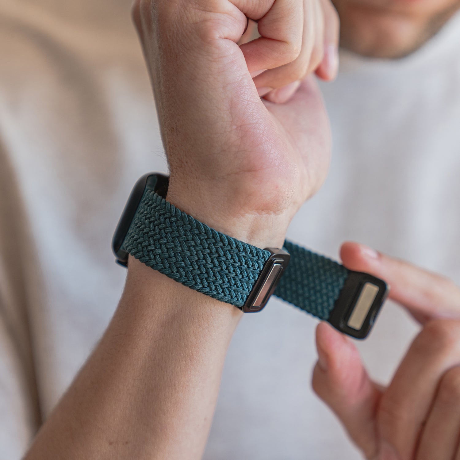 Eine Person befestigt das arktisband Geflochtene Apple Watch Armband „Casual“ mit Magnetverschluss um ihr Handgelenk.