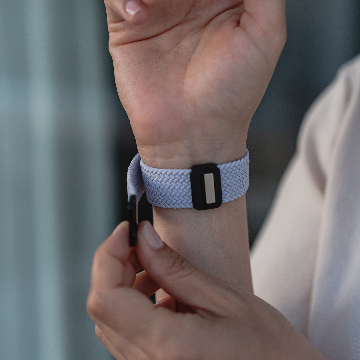 Man befestigt das arktisband Geflochtene Apple Watch Armband „Casual“ in Hellgrau mit schwarzem Magnetverschluss von arktisband am Handgelenk.