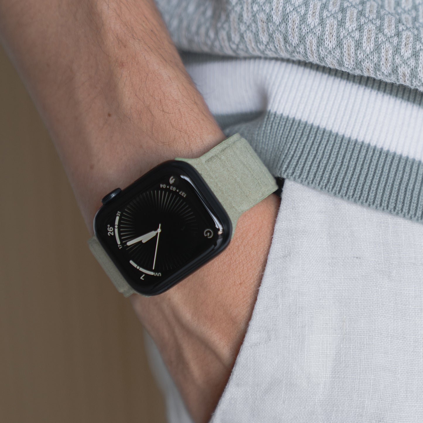 Eine Person trägt ein arktisband Apple Watch Magnetarmband aus Alcantara®, die Hand in der Tasche einer hellen Hose, und verkörpert damit italienisches Lebensgefühl.