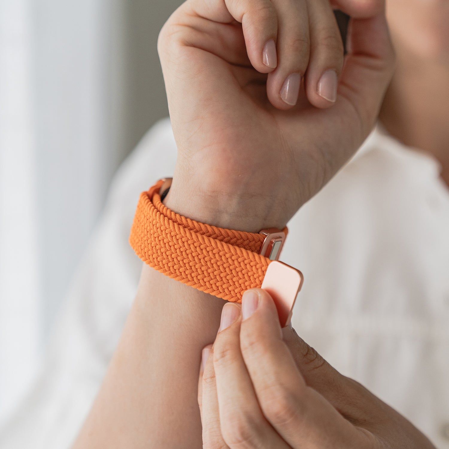 Eine Person befestigt ein arktisband Geflochtenes Apple Watch Armband „Casual“ mit Magnetverschluss von arktisband an ihrem Handgelenk.