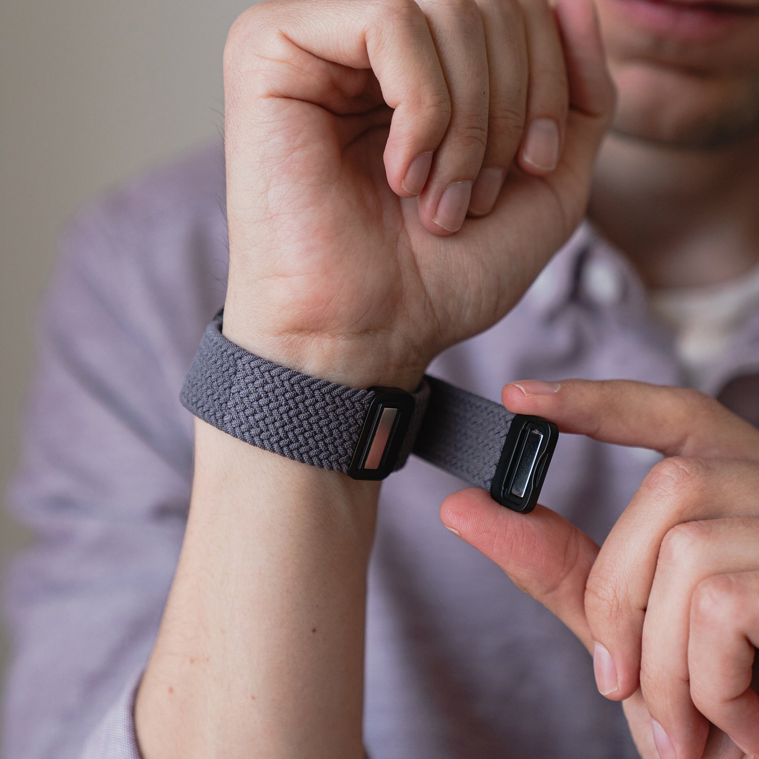 Eine Person befestigt ein kunstvoll geflochtenes Apple Watch Armband „Casual“ mit Magnetverschluss um ihr Handgelenk.