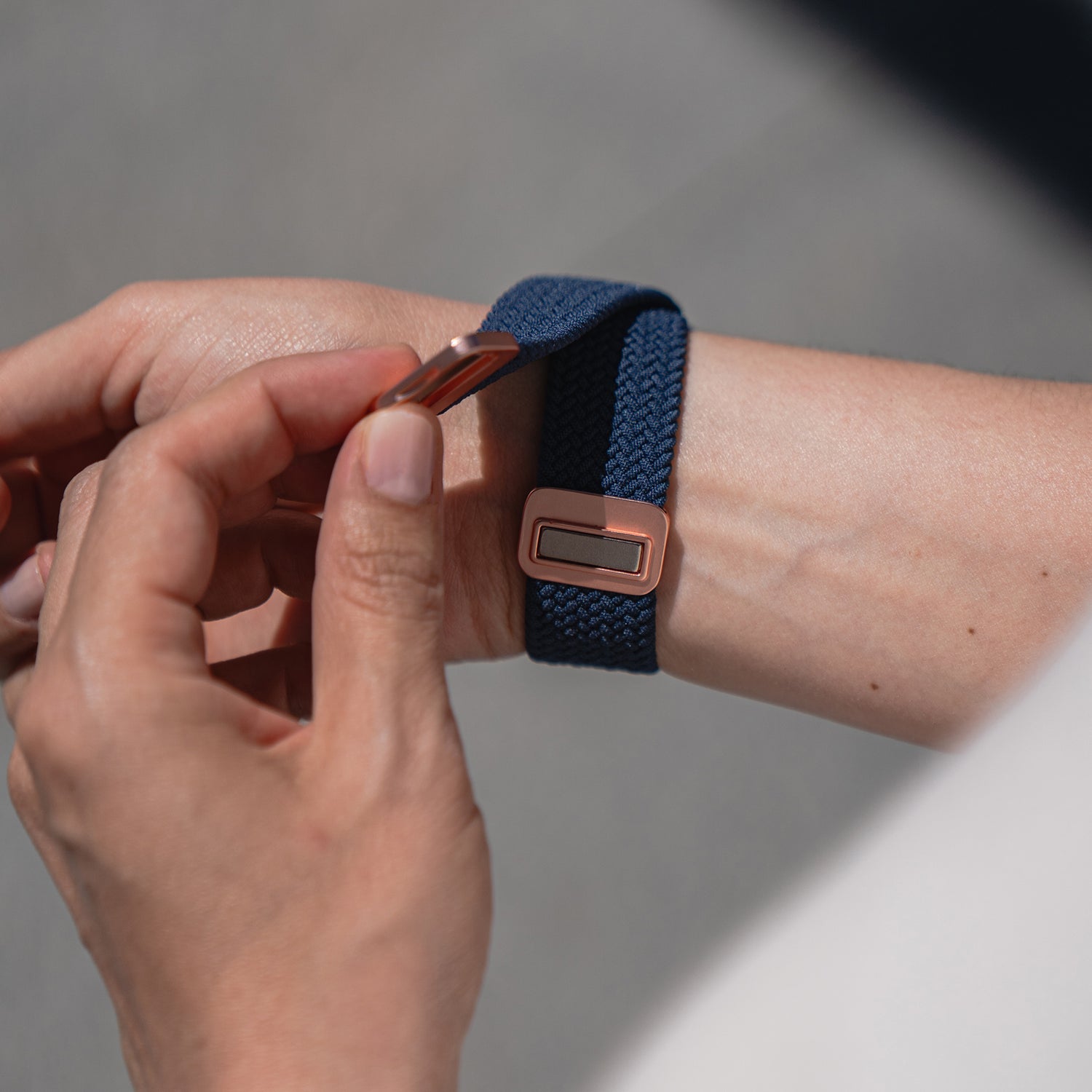 Eine Person befestigt das arktisband Geflochtene Apple Watch Armband „Casual“ mit Magnetverschluss von arktisband am Handgelenk.
