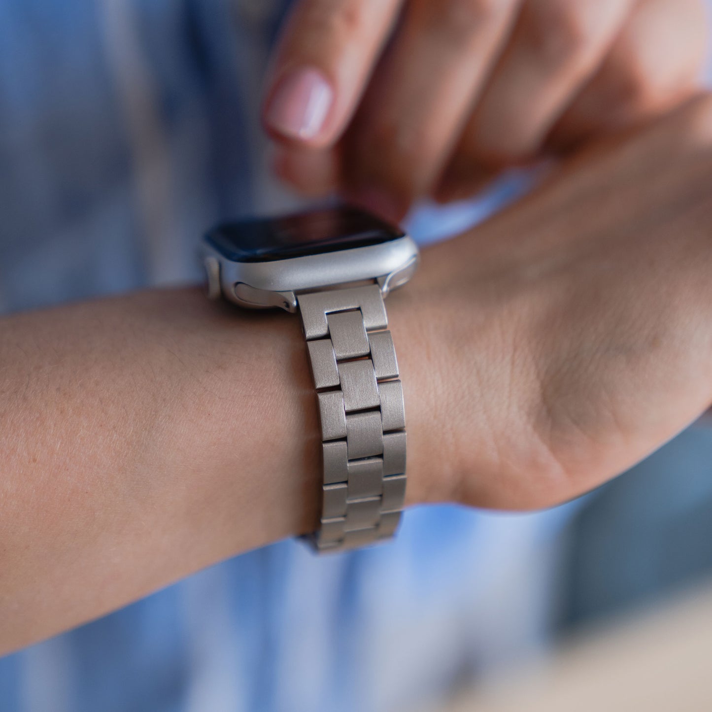 Nahaufnahme einer Person, die das arktisband Apple Watch Gliederarmband „Arctica“ – Slim von arktisband an ihrem Handgelenk anpasst.