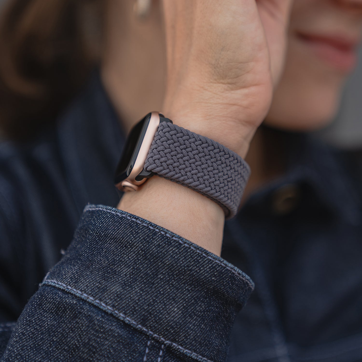 Nahaufnahme einer Person, die das geflochtene Apple Watch Armband „Casual“ mit Magnetverschluss von arktisband trägt, kombiniert mit einem dunklen Jeanshemd.