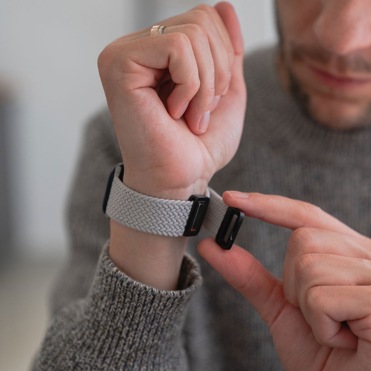 Eine Person entnimmt ein schwarzes Fitness-Tracker-Modul aus einem arktisband Geflochtenes Apple Watch Armband „Casual“ mit Magnetverschluss.