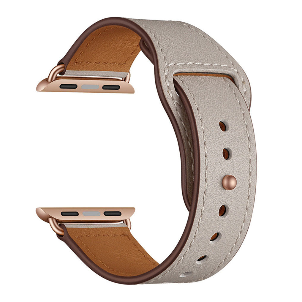 Das arktisband Apple Watch Kunstlederarmband in Beige mit roségoldenen Steckern und braunem Futter überzeugt im minimalistischen Design und wird von arktisband auf weißem Hintergrund präsentiert.