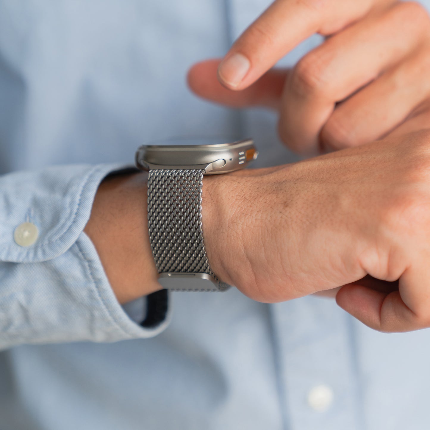 Jemand, der das arktisband Apple Watch Milanaise Armband "Bold" mit Magnetverschluss trägt, passt das elegante Metallnetzband von arktisband an sein Handgelenk an.