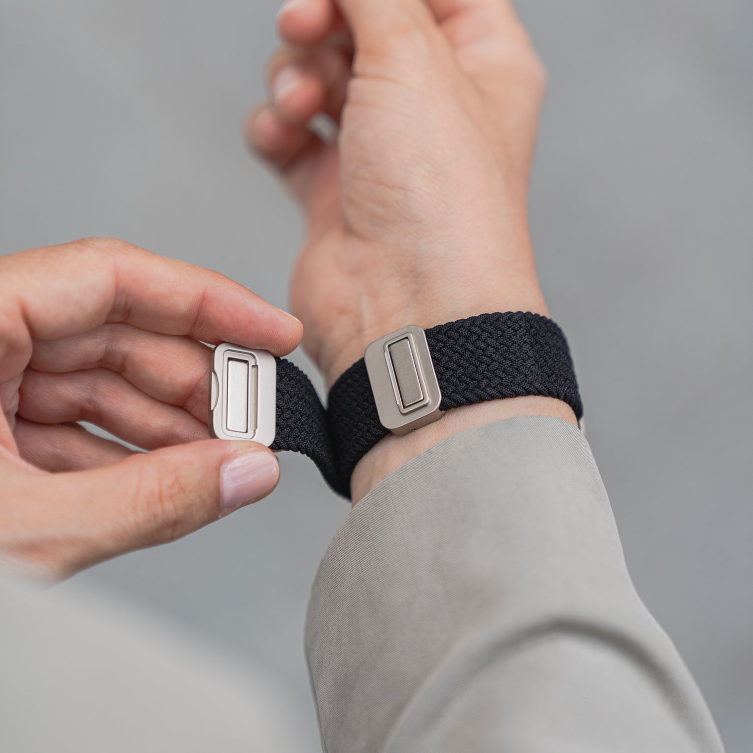 Eine Person befestigt das arktisband Geflochtene Apple Watch Armband „Casual“ mit Magnetverschluss von arktisband um ihr Handgelenk.