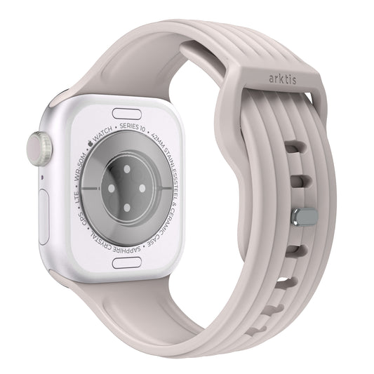 Ein Arktisband Apple Watch Armband "Skandi" in hellgrauem Fluorelastomer, gezeigt von der Rückseite mit Sensoren und gravierten Details sichtbar.