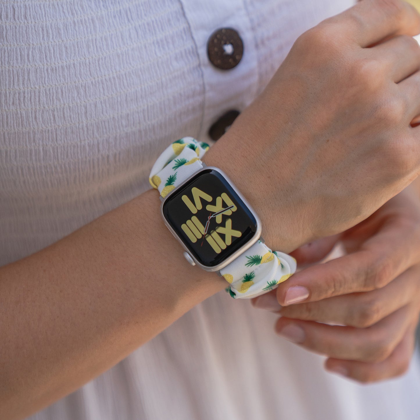 Eine Person trägt ein arktisband Apple Watch Scrunchie Armband "Elanora" mit einem weißen Oberteil mit Knöpfen.