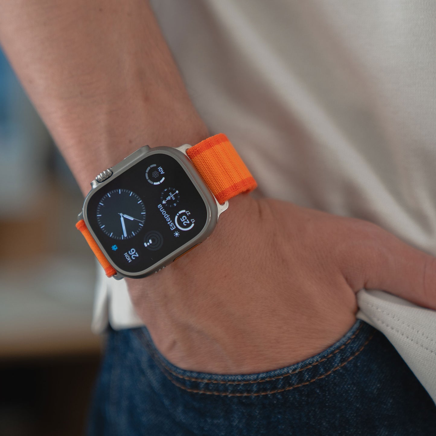 Mit einem arktisband Apple Watch Nylon Armband „Venture“ von arktisband in Orange, der Hand in der Tasche, lässiger Jeans und Shirt – perfekt gerüstet für jedes Abenteuer.