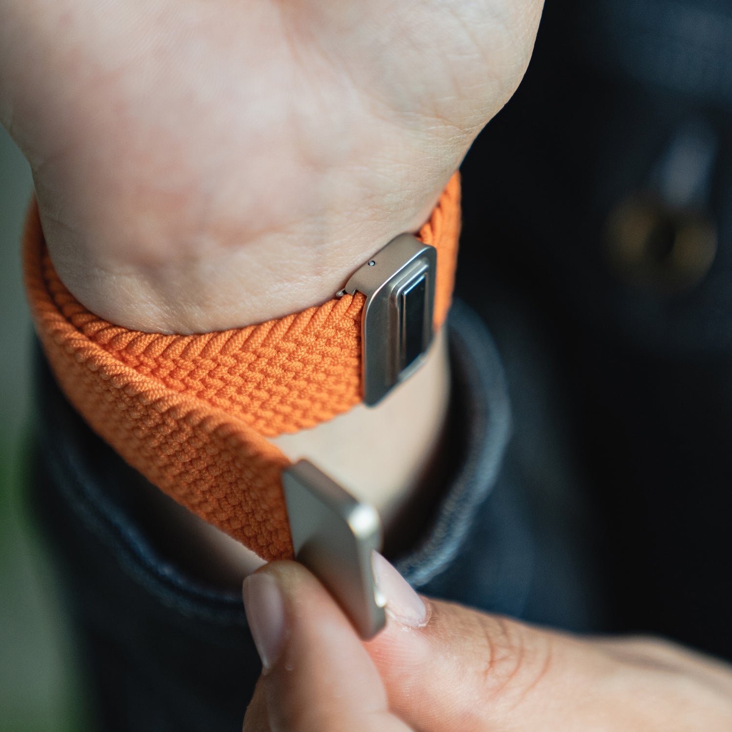 Eine Person befestigt das arttisband Geflochtene Apple Watch Armband „Casual“ mit Magnetverschluss an ihrem Handgelenk.