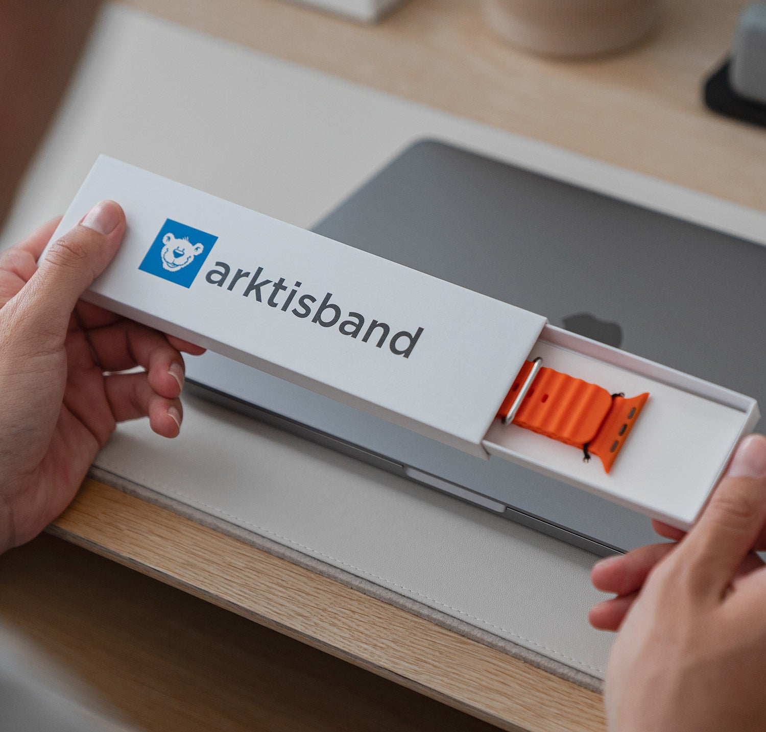 arktisband Verpackung mit orangenem Apple Watch Silikonarmband.