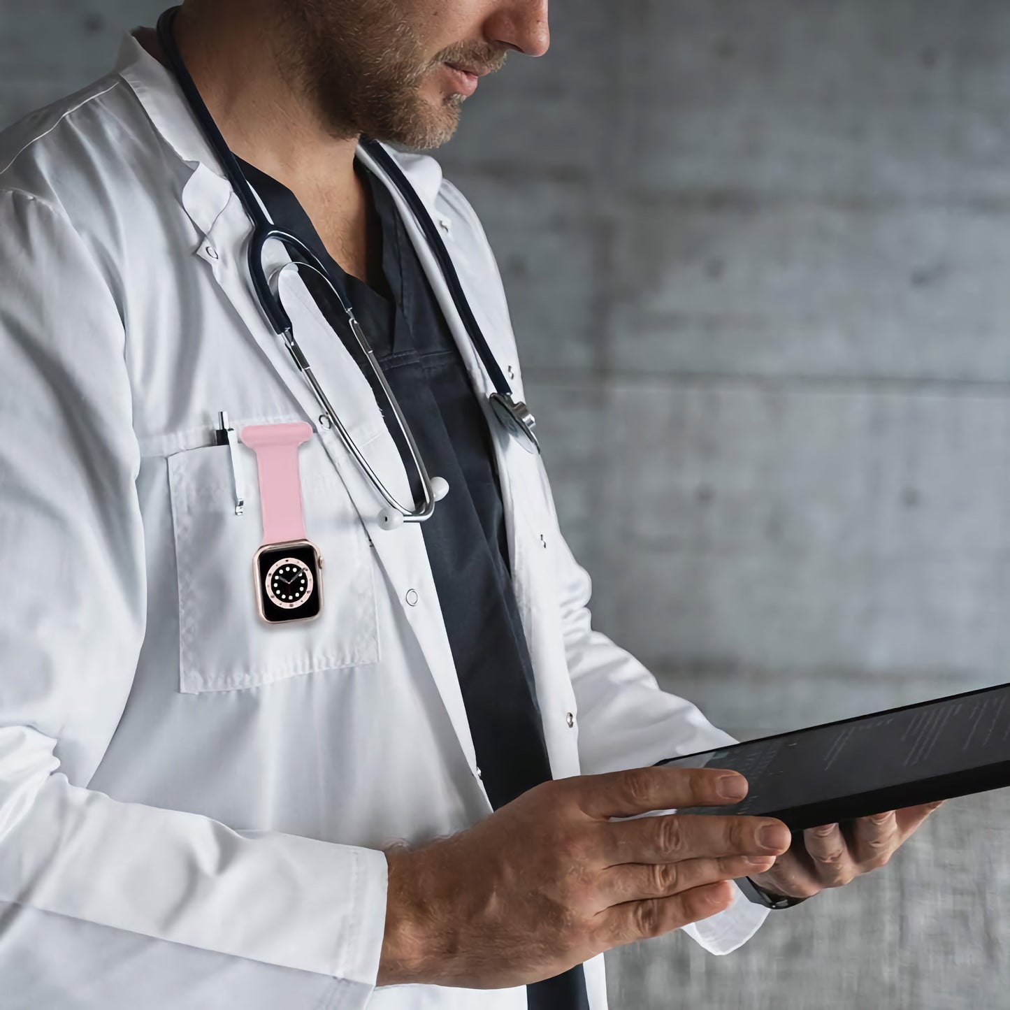 Ein Arzt im weißen Kittel verwendet ein Tablet, ein Stethoskop und ein Arktisband Apple Watch "NurseClip" mit Silikonarmband, das an der Tasche befestigt ist.