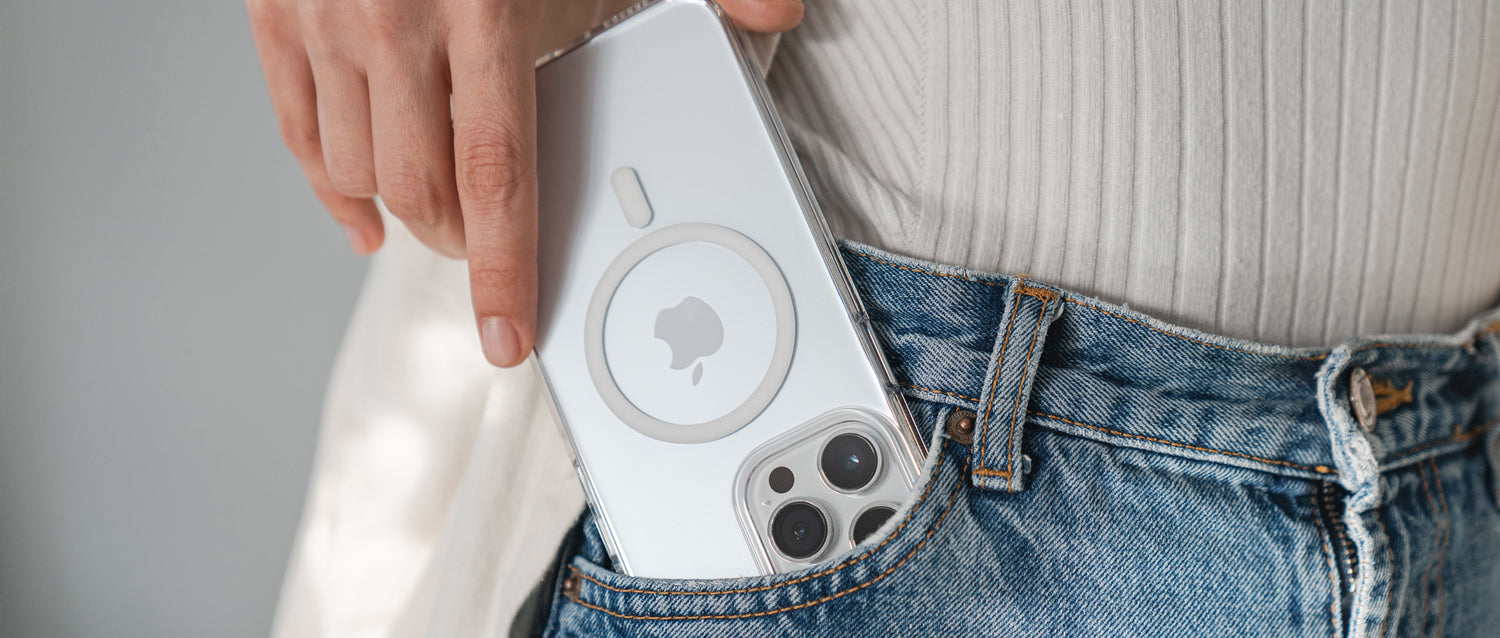 Eine Hand steckt ein iPhone mit einer MagSafe-Hülle in die Vordertasche einer Bluejeans.