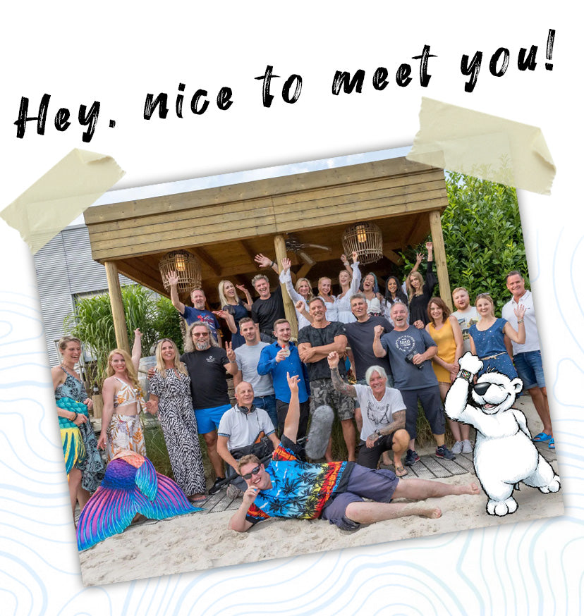 Eine Gruppe von Menschen posiert und lächelt auf einem Holzdeck, darüber steht der Text „Hey, schön, Sie kennenzulernen!“.