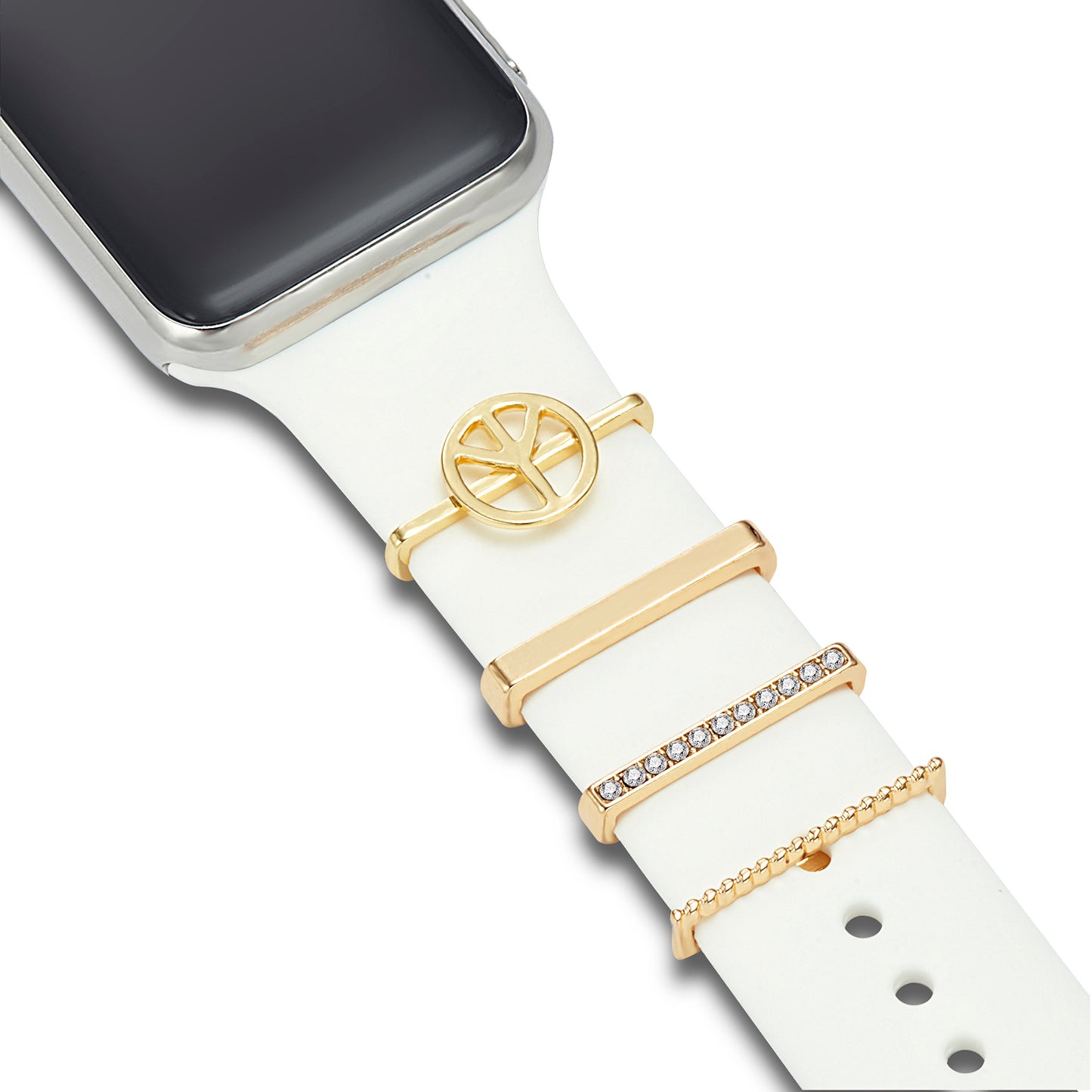 Ein weißes Arktisband-Smartwatch-Armband ist mit den Arktisband Apple Watch Charms „Peace“ in Gold verziert – vier Teile aus Edelstahl und Glas: ein runder Charm, zwei rechteckige Balken und eine Perlenreihe. Das Zifferblatt ist teilweise sichtbar.