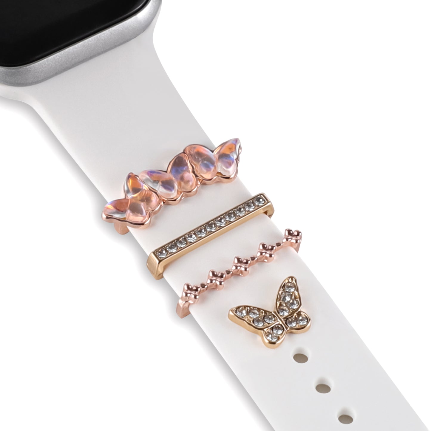 Personalisieren Sie Ihren Look mit den arktisband Apple Watch Armband Charms von arktisband – mit einem weißen Band und vier Charms: schillernden Schmetterlingen, einem goldenen Balken mit klaren Steinen, goldenen Schleifen und einem goldenen Schmetterling.
