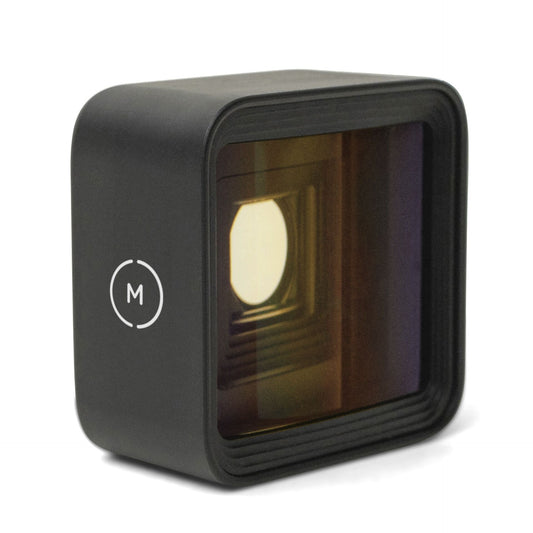 Das MOMENT 1,33x Anamorphot-Objektiv der T-Serie ist ein schwarzes, quadratisches Objektiv mit einer spiegelnden Oberfläche und einem weißen M-Logo - ideal für Smartphone-Setups zum Filmen.