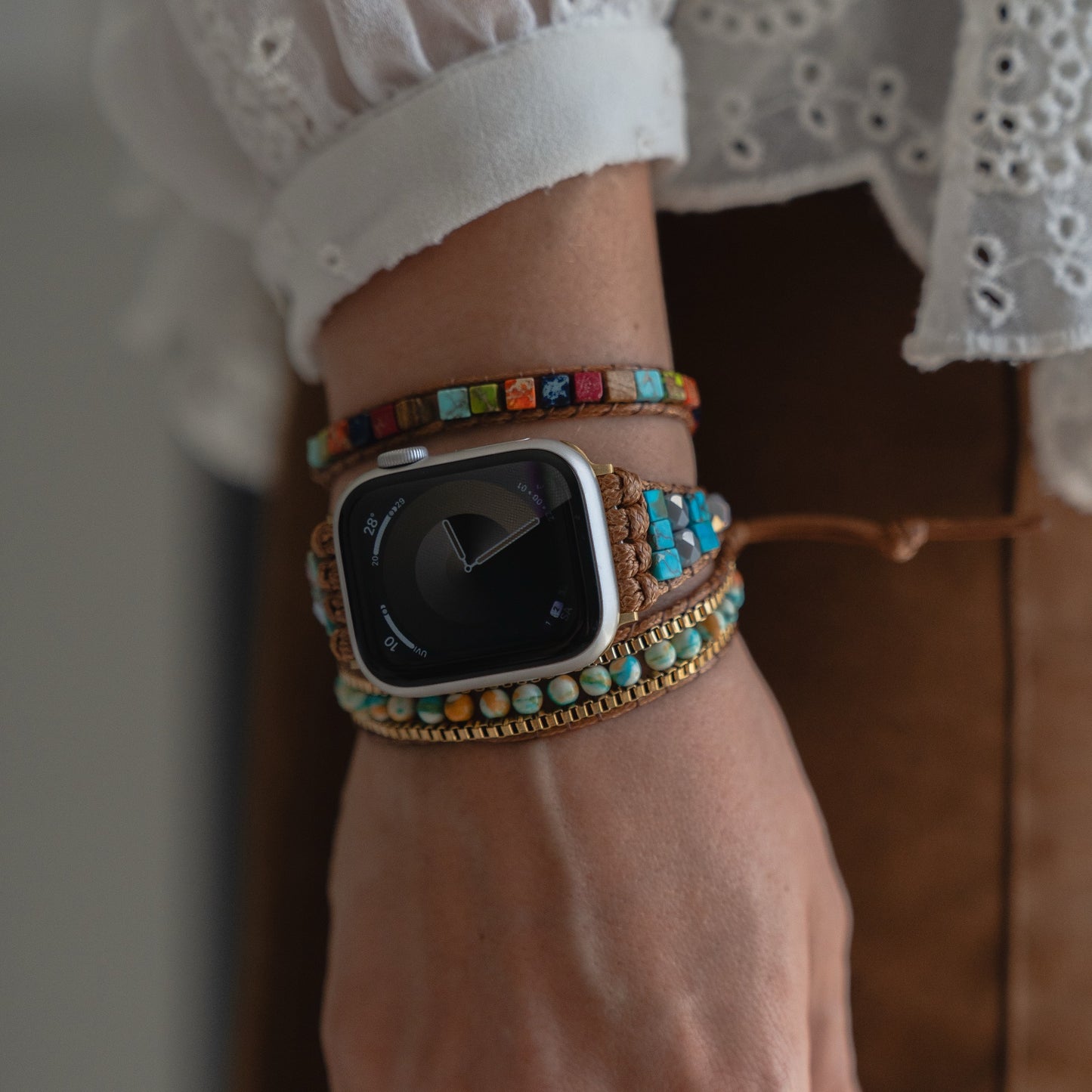 Eine Person trägt ein arktisband Apple Watch Armband "Dream Catcher" von arktisband und bunte Perlenarmbänder an ihrem Handgelenk.