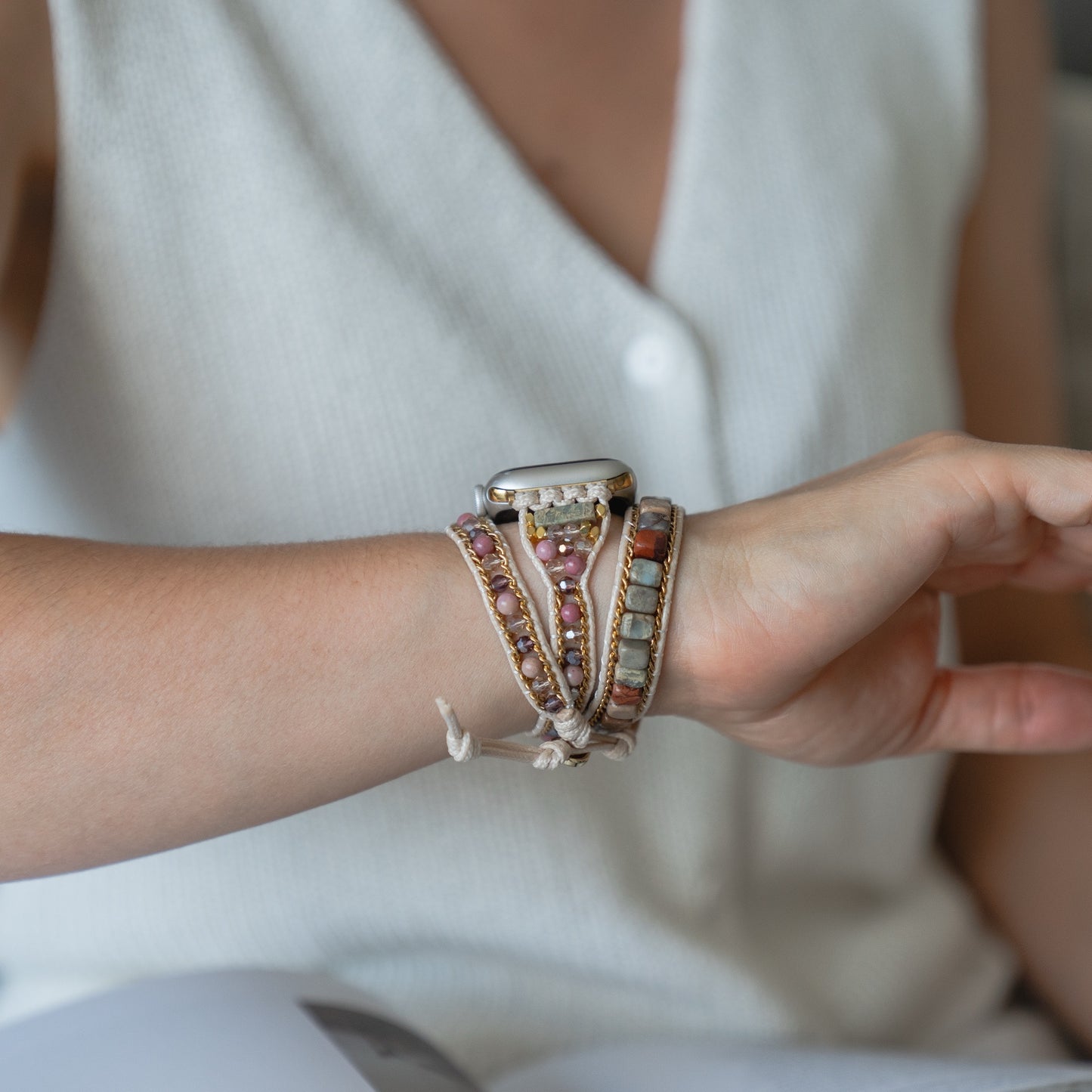 Eine Person trägt das arktisband Apple Watch Armband "Dream Catcher" mit einem Edelstahladapter und einem weißen ärmellosen Oberteil.