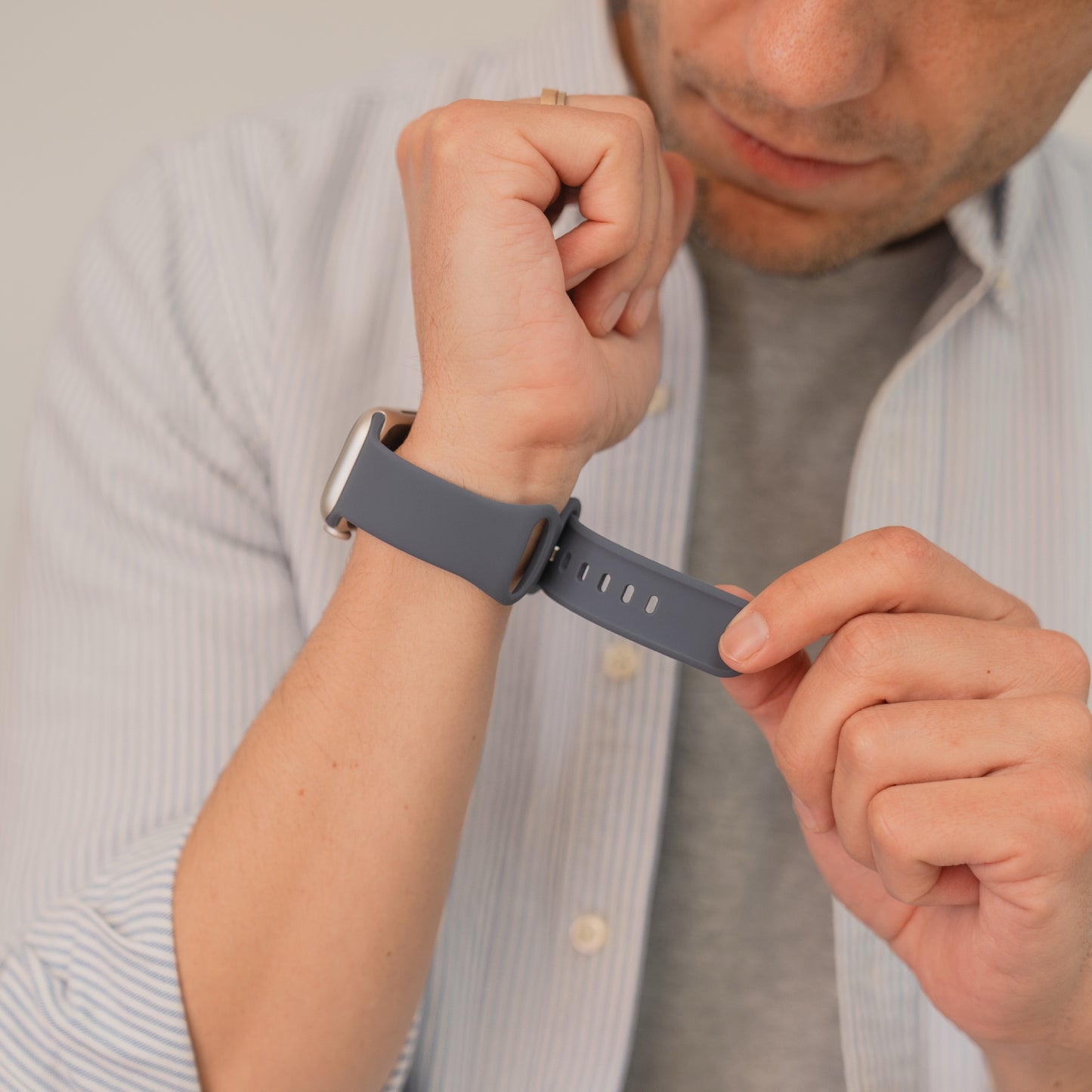 Eine Person befestigt ein arktisband Apple Watch Silikonarmband "Sport" mit blauem Band am Handgelenk, ideal als Armband für Alltag und Sport von arktisband.