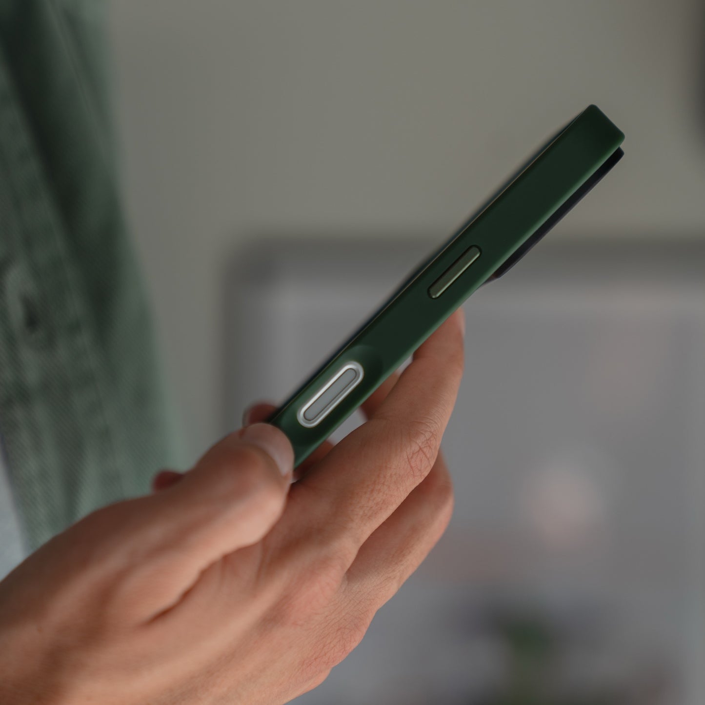 Eine Person hält ein iPhone 17 Pro mit einer grünen, matten Arktis iPhone 17 Pro Solid Case von Arktis, wobei der Fokus auf der Seitenansicht und der Hand liegt und das schlanke, robuste TPU-Silikon-Design hervorgehoben wird.