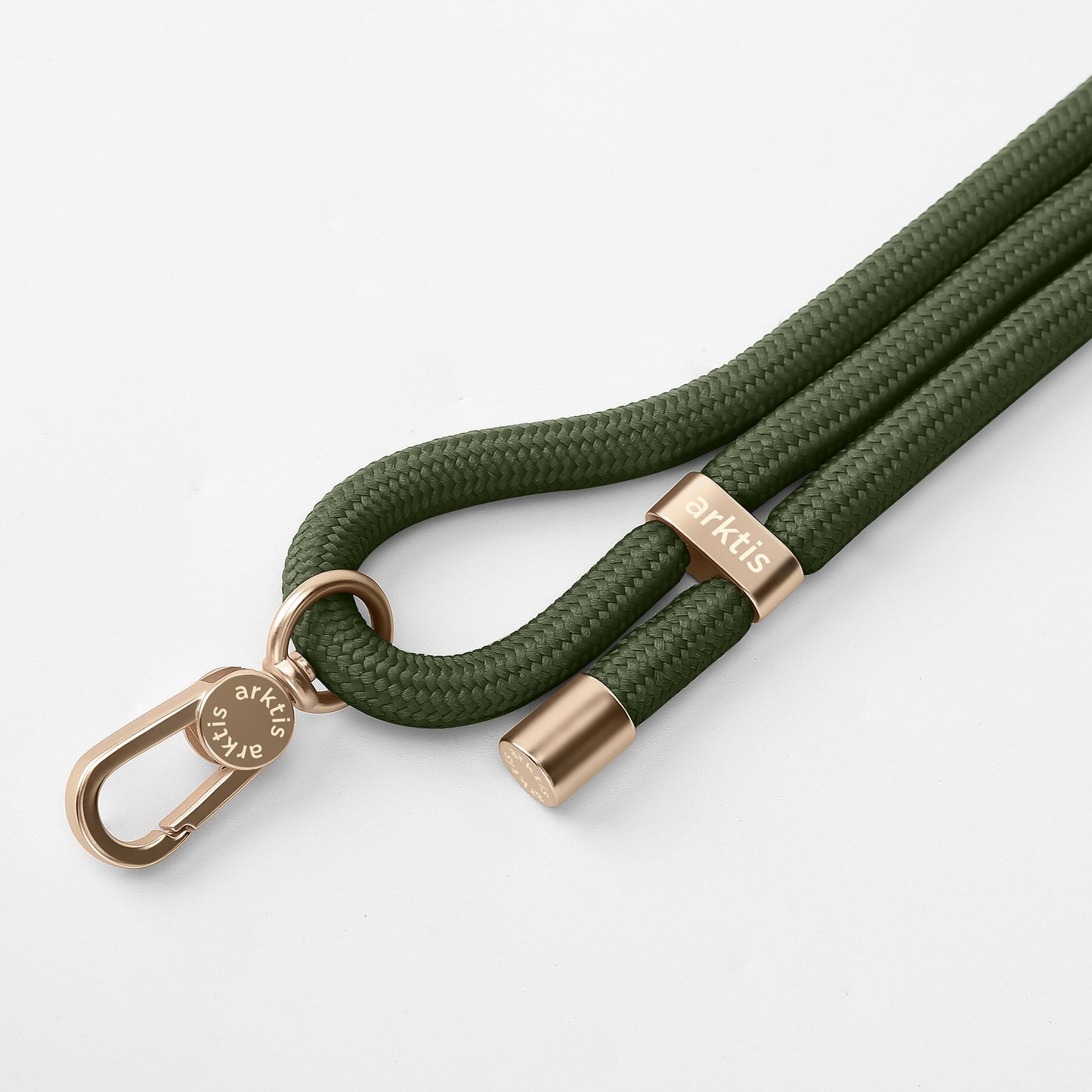 Die Arktis Lanyard Handykette fürs Handgelenk von Arktis ist ein grünes, geflochtenes Smartphone-Zubehör mit goldenen Metallakzenten und Verschluss, wobei sowohl auf dem Verschluss als auch auf dem Metallende der Markenname eingraviert ist, abgebildet vor einem schlichten weißen Hintergrund.