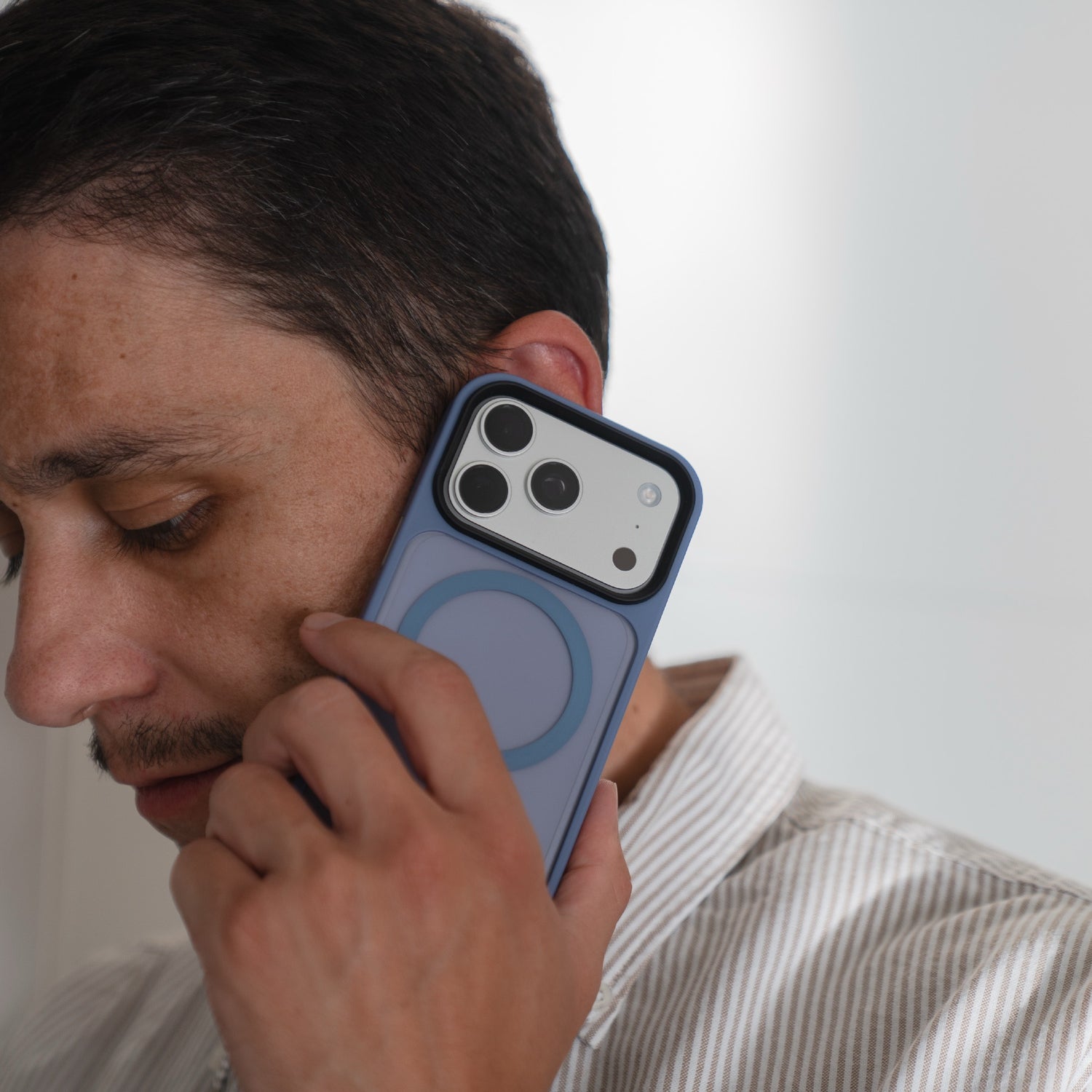 Eine Person hält ein iPhone 17 Pro während eines Anrufs an ihr Ohr, geschützt durch das Arktis arktis iPhone 17 Pro Solid Case mit MagSafe.