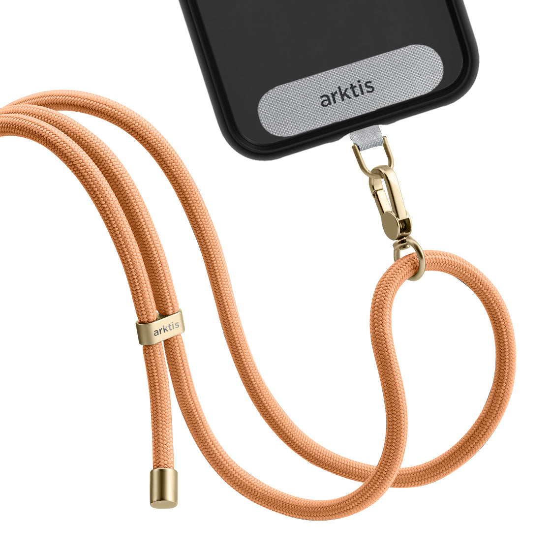 Eine Nahaufnahme der schwarzen Arktis Lanyard-Handykette zum Umhängen der Smartphone-Hülle von Arktis, befestigt an einem pfirsichfarbenen Schlüsselband mit goldenen Beschlägen und Arktis-Branding sowohl auf der Hülle als auch auf der Kordel.