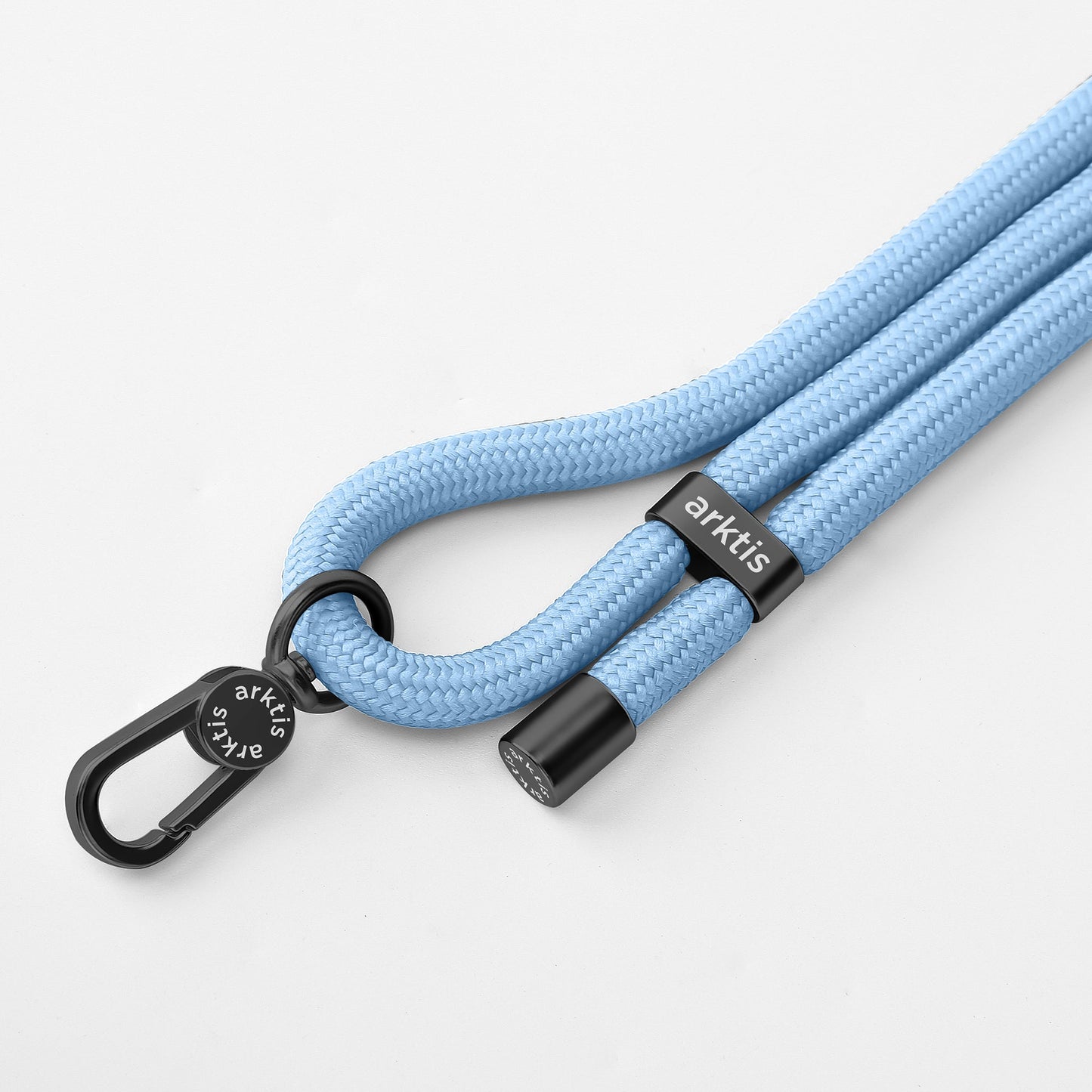 Die arktis Lanyard Handykette fürs Handgelenk von Arktis verfügt über ein hellblaues geflochtenes Design, einen schwarzen Metallverschluss, das Arktis-Branding und eine einstellbare Länge – ein stilvolles Smartphone-Zubehör auf weißem Hintergrund.