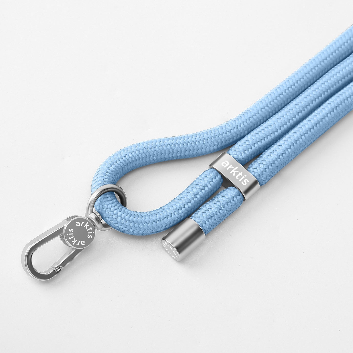 Die arktis Lanyard Handykette fürs Handgelenk von Arktis besteht aus einem hellblauen geflochtenen Seil mit silbernen Akzenten und Verschluss und eignet sich ideal als stylisches Smartphone-Accessoire oder Mode-Accessoire. Auf weißem Hintergrund dargestellt.