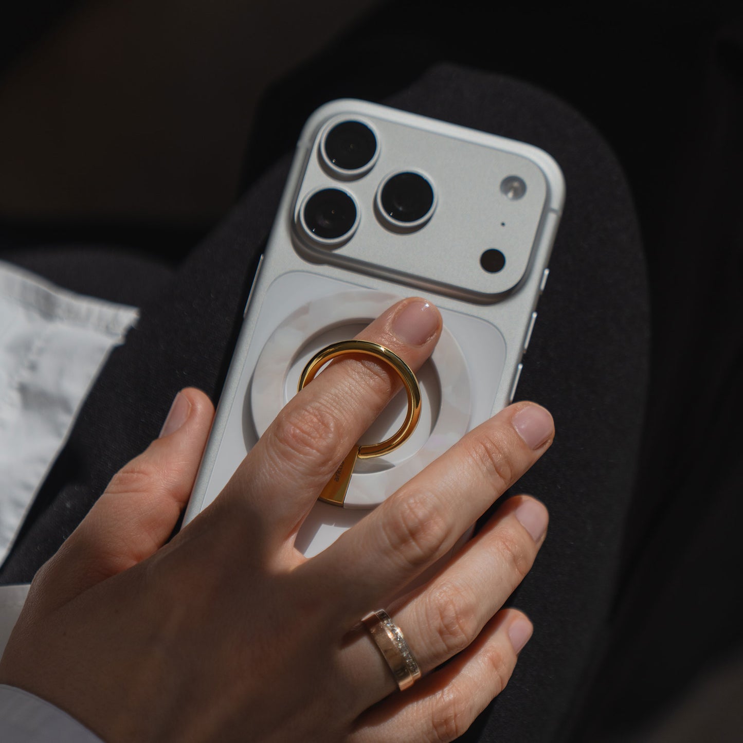 Eine Hand hält ein weißes Telefon mit dem arktis Magnetischer Ringhalter für MagSafe - Sweet Leopard, mit starkem N52 Magneten - ein stilvolles und sicheres iPhone Zubehör.