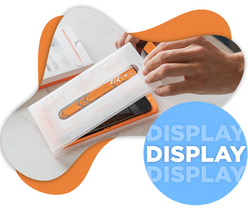 Eine Hand öffnet ein Plastikgehäuse, das ein orangefarbenes elektronisches Gerät auf einer weißen Oberfläche enthält.