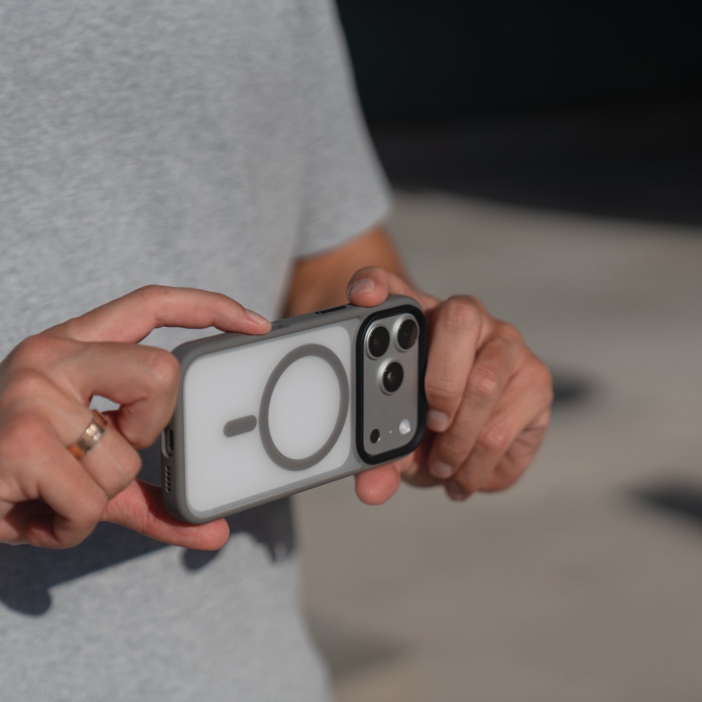 Im Freien hält eine Person ein iPhone 17 Pro mit der weißen, matten Arktis Solid Case Schutzhülle mit MagSafe von Arktis in beiden Händen.