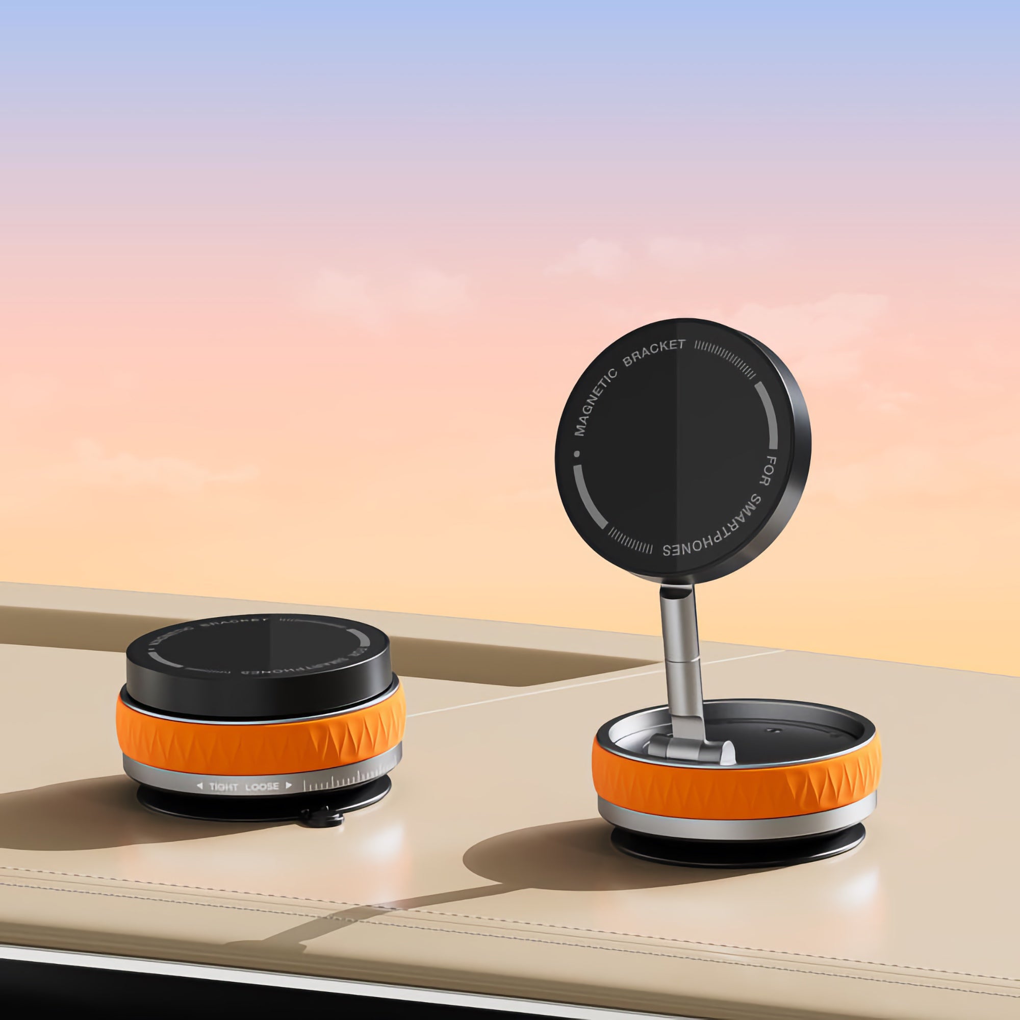 Zwei runde, orange-schwarze magnetische Telefonhalter auf einer beigen Oberfläche mit einem Sonnenuntergangshimmel im Hintergrund.
