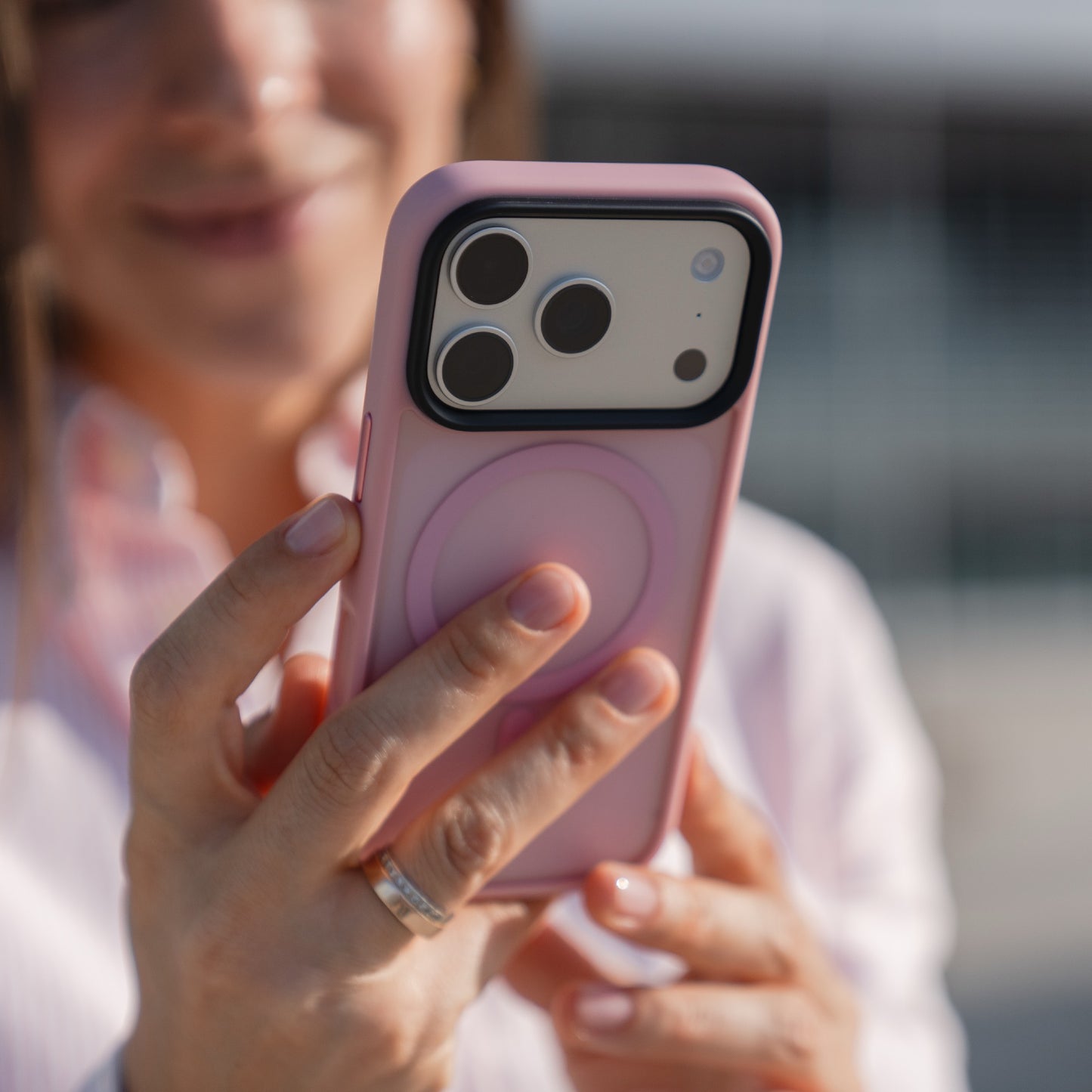 Eine Person hält ein Smartphone mit einer rosafarbenen, matten Hülle, die die Kameralinsen hervorhebt - ideal für die Präsentation des Arktis iPhone 17 Pro Solid Case mit MagSafe von Arktis.