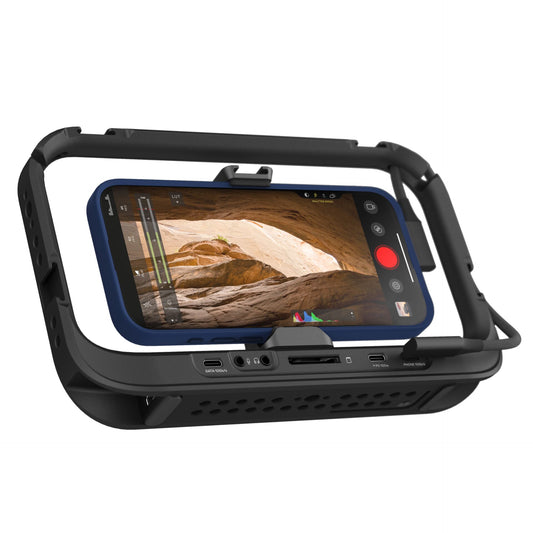 Der MOMENT Moment Supercage mit USB-C Hub in robustem Schwarz hält Ihr Smartphone und zeigt eine Kamera-App mit einer Wüstenhöhle an - ideal für iPhone-Filmemacher, die Aufnahmen auf Profi-Niveau machen wollen.