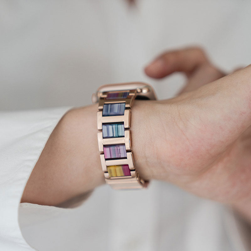 Apple Watch Amband aus Edelstahl mit goldenen und bunten Elementen.