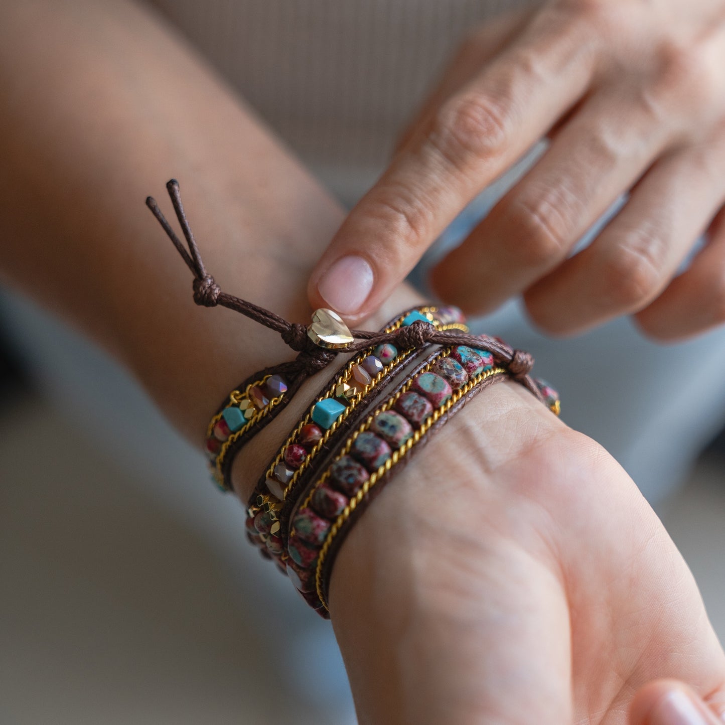 Jemand passt das arktisband Apple Watch Armband "Dream Catcher" von arktisband, ein Perlenarmband im Boho-Stil, mit der anderen Hand an sein Handgelenk an.