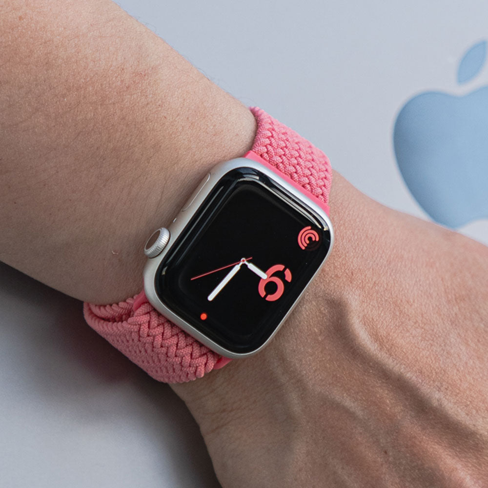 Apple Watch mit pinken Armband aus geflochtenem Nylon.