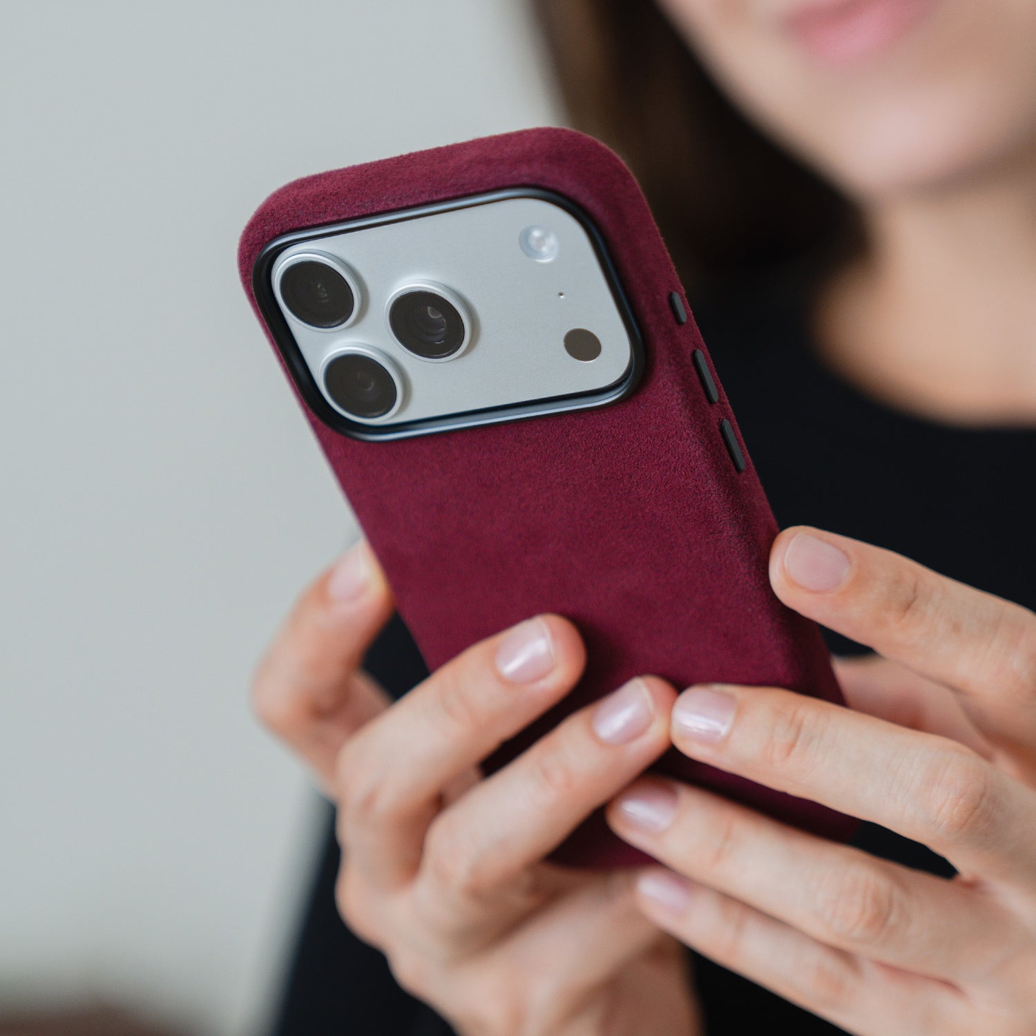 Eine Person hält ein Smartphone mit der arktis iPhone 17 Pro Hülle aus Alcantara von arktis, wobei die Dreifachkamera des Telefons und die elegante Alcantara-Struktur der Hülle zur Geltung kommen.