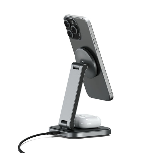 Ein Smartphone und Ohrhörer werden auf dem Satechi 2-in-1 Foldable Qi2 Wireless Charging Stand aufgeladen, der sich durch ein schlankes Design auszeichnet und ein iPhone Ladegerät und eine AirPods Ladestation über ein angeschlossenes Kabel unterstützt.