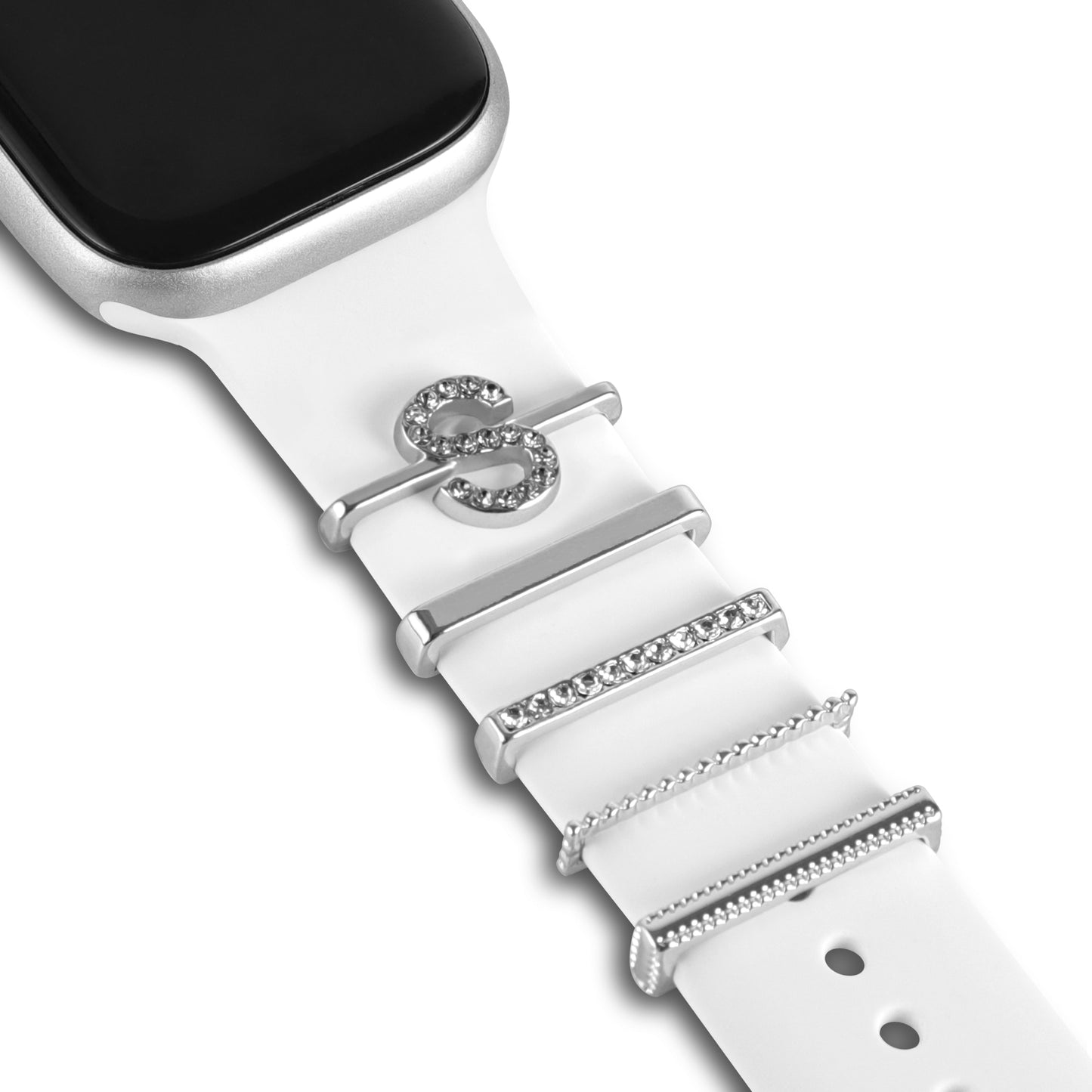 Nahaufnahme einer Smartwatch mit silbernem Gehäuse und weißem Arktisband, mit vier Arktisband-Apple-Watch-Charms im „S-Stil“, darunter ein funkelnder Charm in Form des Buchstabens S.