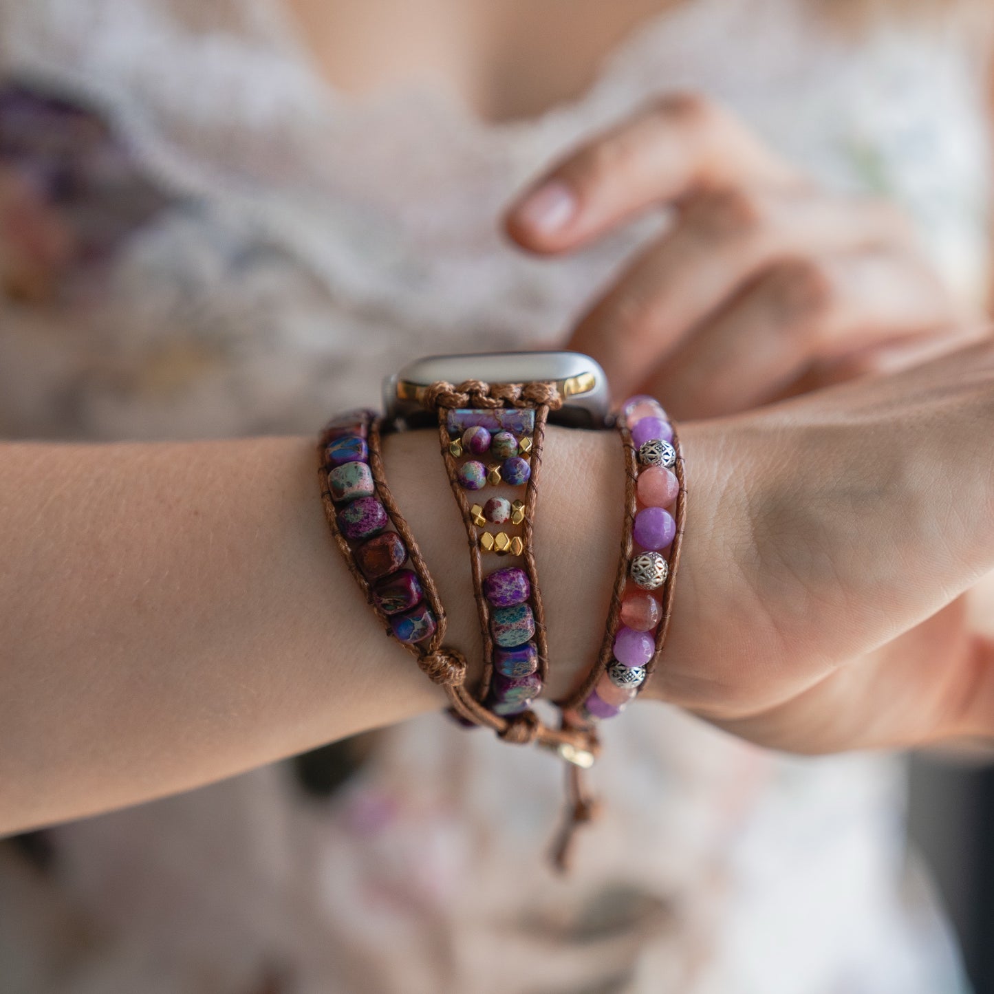 Jemand trägt ein perlenbesetztes, lila und braunes Boho Armband neben dem arktisband Apple Watch Armband "Dream Catcher" mit Edelstahladapter am Handgelenk.