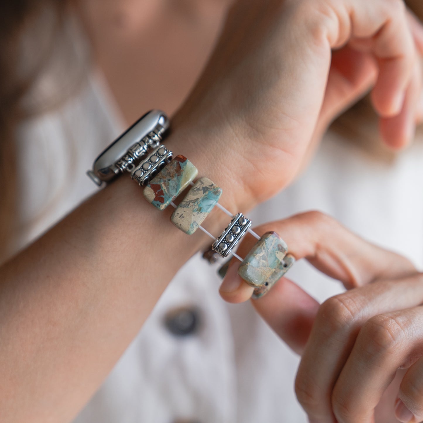 Eine Hand verstellt die arktisband Apple Watch "Stone Loop", ein klobiges, mehrfarbiges Band von arktisband, das Ihrer Uhr einen einzigartigen und lebendigen Stil verleiht.