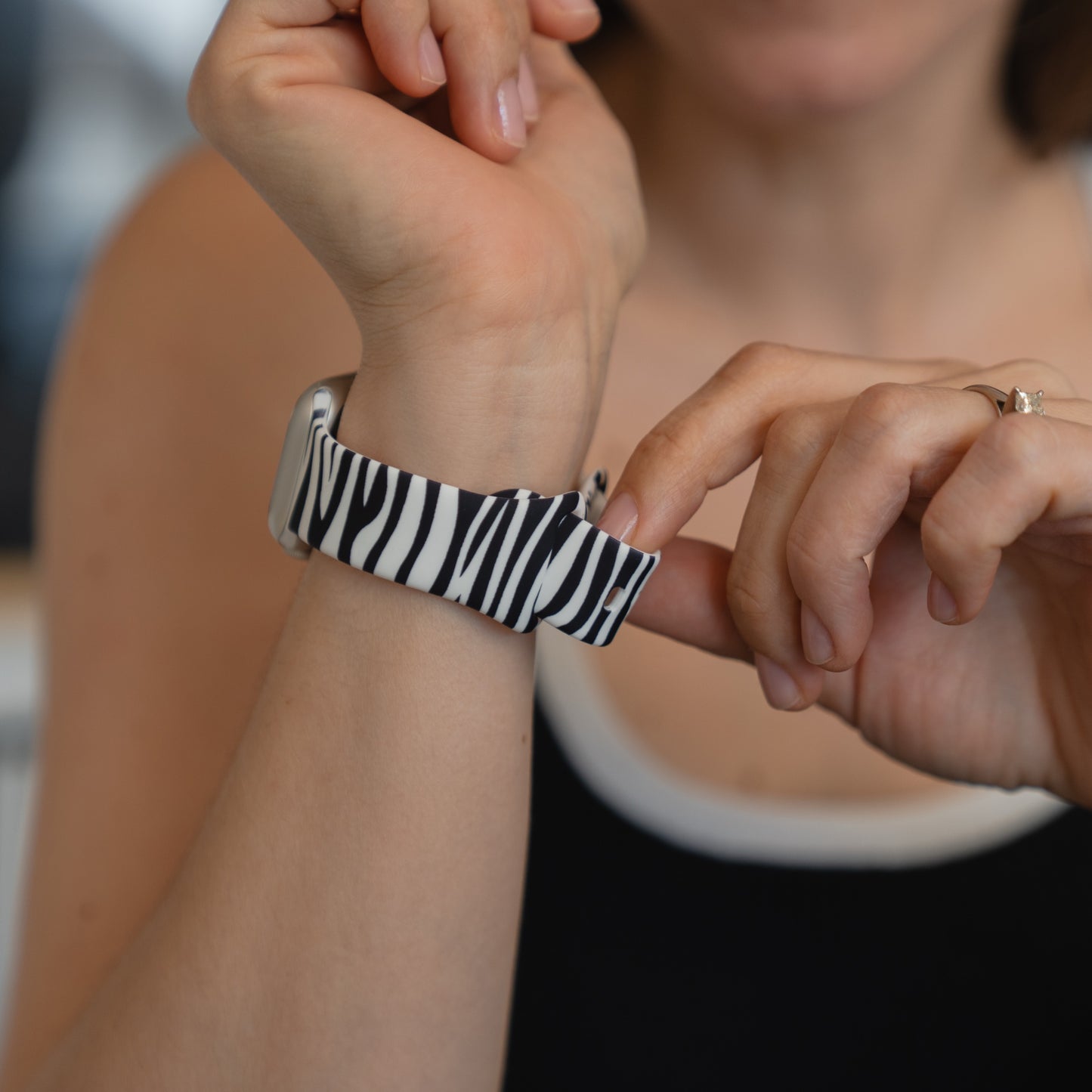 Eine Person trägt das arktisband Zebra Apple Watch Armband von arktisband, das mit seinem schwarz-weißen Zebra-Streifen-Design für einen sportlichen Look sorgt.