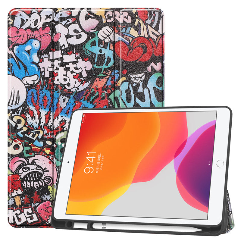 Ein ArktisPRO iPad 10,2" PREMIUM SmartCase im farbenfrohen Graffiti-Stil mit abstrakten Designs und Text, ausgestattet mit einem Apple Pencil-Halter. Das iPad steht teilweise aufrecht und zeigt einen Startbildschirm in leuchtenden Orange- und Pinktönen.