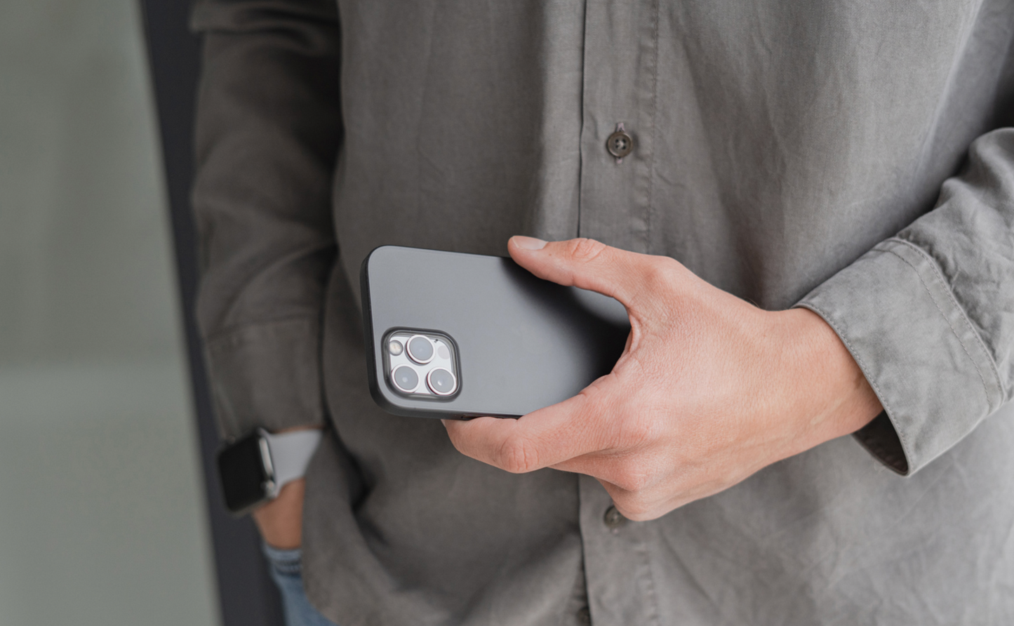 Person mit grauem Hemd hält eine ArktisPRO iPhone 13 Pro Max Hülle ULTRADÜNN von ArktisPRO in der Hand.